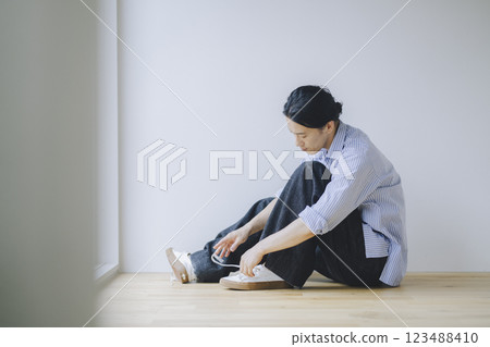 A man in his 40s tying his sneaker laces A man in his 40s tying his sneaker laces 123488410