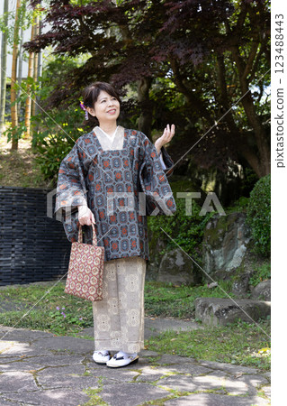 A woman in a kimono wearing a dokoyō coat 123488443