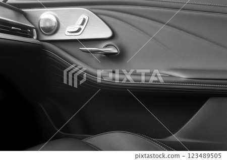 Door handle with Power seat control buttons of a passenger car. Black leather interior of modern car. Car interior details Door handle with Power seat control buttons of a passenger car. Black leather interior of modern car. Car interior details 123489505
