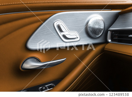 Door handle with Power seat control buttons of a luxury passenger car. Brown leather interior of the luxury modern car. Modern car interior details Door handle with Power seat control buttons of a luxury passenger car. Brown leather interior of the luxury modern car. Modern car interior details 123489538