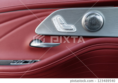 Door handle with Power seat control buttons of a luxury passenger car. Red leather interior of the luxury modern car. Modern car interior details 123489540