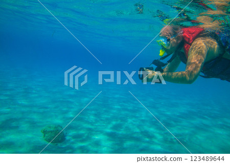 Man with photo camera taking photos and snorkeling underwater by coral reef in the Red sea, Egypt 123489644