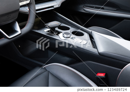 Automatic transmission shift selector in the modern car black leather interior. Selector automatic transmission in premium car. Gear shift lever. Automatic gearbox lever. Automatic transmission shift selector in the modern car black leather interior. Selector automatic transmission in premium car. Gear shift lever. Automatic gearbox lever. 123489724