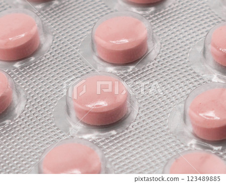 Macro shot pile of tablets pill in silver blister packaging isolated on white background. Aluminium foil blister pack. Pharmacy products. Medicine pills and drugs close up. Pills background 123489885
