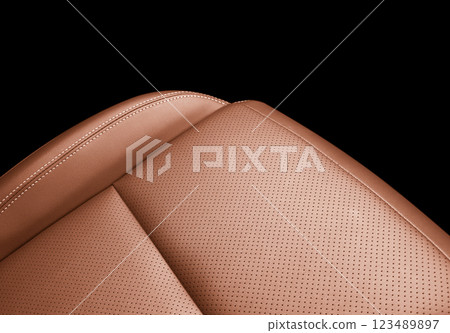 Car brown leather interior. Part of brown leather car seat details with white stitching. Interior of prestige car. Perforated leather seats isolated on black. Perforated leather. Car brown leather interior. Part of brown leather car seat details with white stitching. Interior of prestige car. Perforated leather seats isolated on black. Perforated leather. 123489897