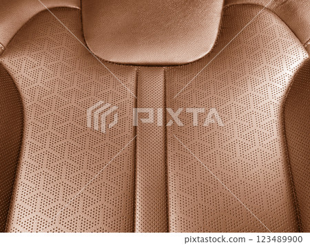 Car brown leather interior. Part of brown leather car seat details with white stitching. Interior of prestige car. Perforated leather seats isolated. Perforated leather. Car brown leather interior. Part of brown leather car seat details with white stitching. Interior of prestige car. Perforated leather seats isolated. Perforated leather. 123489900