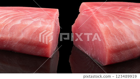 Yellow fin tuna steak isolated on black background. Fresh rare tuna steak isolated. Raw yellowfin tuna fillet texture. Background fresh fish meat. Top view of slices of tuna meat. Yellow fin tuna steak isolated on black background. Fresh rare tuna steak isolated. Raw yellowfin tuna fillet texture. Background fresh fish meat. Top view of slices of tuna meat. 123489919