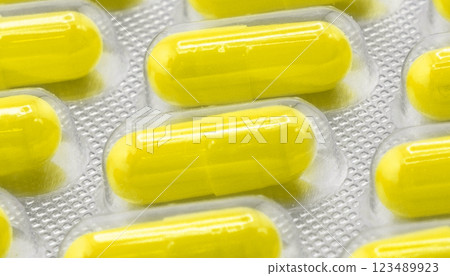 Macro shot pile of tablets pill in silver blister packaging isolated on white background. Aluminium foil blister pack. Pharmacy products. Medicine pills and drugs close up. Pills background Macro shot pile of tablets pill in silver blister packaging isolated on white background. Aluminium foil blister pack. Pharmacy products. Medicine pills and drugs close up. Pills background 123489923