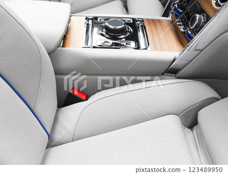 Modern luxury car white leather interior with natural wood panel. Part of leather car seat details with stitching. Interior of prestige modern car. White perforated leather. Car inside Modern luxury car white leather interior with natural wood panel. Part of leather car seat details with stitching. Interior of prestige modern car. White perforated leather. Car inside 123489950