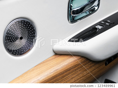 Door handle with power window control buttons of a luxury passenger car. White perforated leather interior with stitching and wood panel. Modern car interior details.. Car inside Door handle with power window control buttons of a luxury passenger car. White perforated leather interior with stitching and wood panel. Modern car interior details.. Car inside 123489961