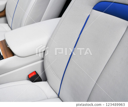Modern luxury car white leather interior seat details with stitching. Interior of prestige modern car. White perforated leather. Car inside. Modern luxury car white leather interior seat details with stitching. Interior of prestige modern car. White perforated leather. Car inside. 123489963