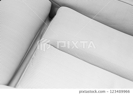 White leather interior of the luxury modern car. Perforated white leather comfortable seats with stitching. Modern car interior details. 123489966