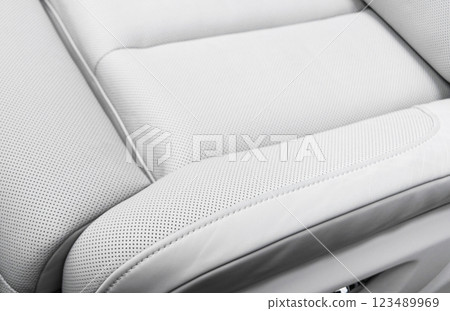 White leather interior of the luxury modern car. Perforated white leather comfortable seats with stitching. Modern car interior details. 123489969