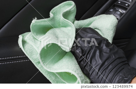 A man cleaning car seat with blue microfiber cloth. Car detailing. Cleaning with sponge. Car wash concept 123489974