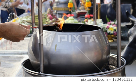 A pot for holding fuel for burning incense sticks and candles to worship sacred objects of Buddhists or Hindu Brahmins	 123491132