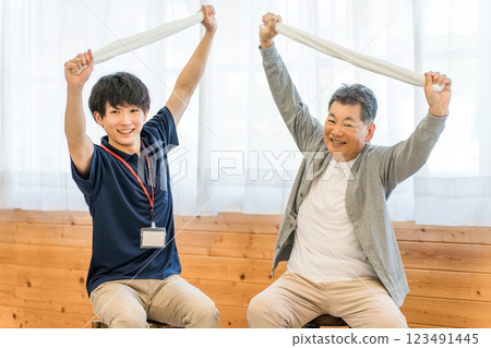 在療養院進行毛巾鍛煉/鍛煉/康復的高級/老年男性和女性以及物理治療師/護理人員/培訓師 123491445