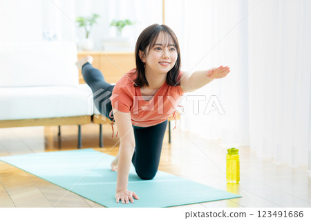 Young woman doing yoga in the living room Young woman doing yoga in the living room 123491686