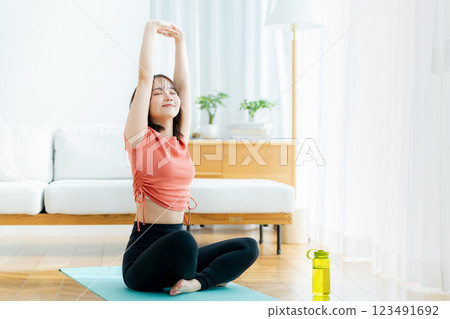 Young woman doing yoga in the living room Young woman doing yoga in the living room 123491692