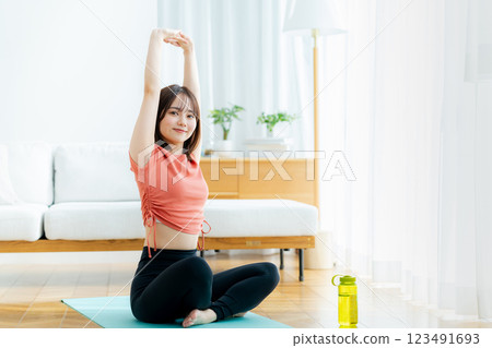 年輕女子在客廳裡做瑜伽 123491693