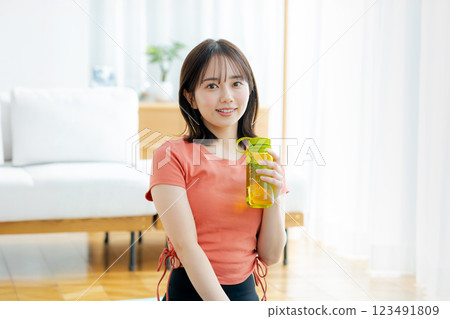 年輕女子在客廳裡做瑜伽 年輕女子在客廳裡做瑜伽 123491809