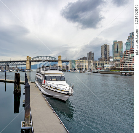 Tourist tour boat moored at the pier with Burrard bridge and Vancouver downtown on the background 123492043