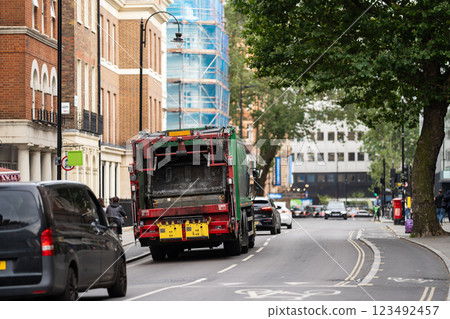 A green garbage truck navigates a London street, symbolizing the city dedication to sustainability amid a backdrop of classic British architecture. A green garbage truck navigates a London street, symbolizing the city dedication to sustainability amid a backdrop of classic British architecture. 123492457