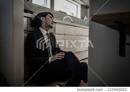 一個因加班而疲憊不堪回到家的商人（思考、絕望、沮喪、努力） 123492632