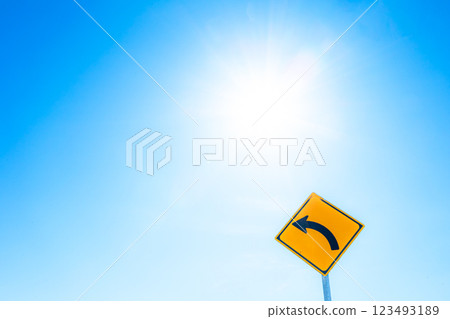 左轉標誌的圖片,背景為陽光和藍天 左轉標誌的圖片,背景為陽光和藍天 123493189
