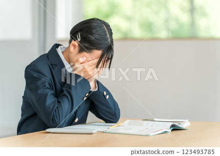 Girls studying in junior high and high school (homework, studying for exams, learning, weakness, education, worries, stress, anxiety, confusion) 123493785