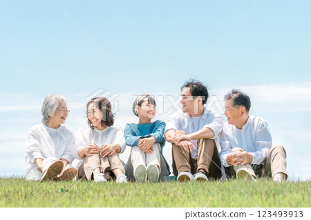 一個可以看到藍天的公園,一個坐在山上的家庭,父母和孩子,一個三代家庭(父親,母親,女兒,祖母,祖父) 一個可以看到藍天的公園,一個坐在山上的家庭,父母和孩子,一個三代家庭(父親,母親,女兒,祖母,祖父) 123493913