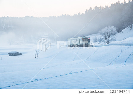 Ojiya City, Niigata Prefecture, Iiyama Line: A single-car train running through the snowy fields of fog and morning glow Ojiya City, Niigata Prefecture, Iiyama Line: A single-car train running through the snowy fields of fog and morning glow 123494744