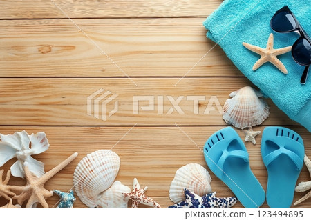 Different seashells with towels and flip flops on brown wooden table Different seashells with towels and flip flops on brown wooden table 123494895