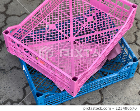 Brightly colored crates are stacked together in a lively market filled with activity, ready to display various goods for eager customers Brightly colored crates are stacked together in a lively market filled with activity, ready to display various goods for eager customers 123496570