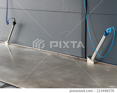Two high-pressure car washer guns are mounted on a clean, smooth surface at a car wash, ready to provide a thorough cleaning experience for vehicles 123496576