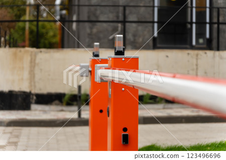 The photograph showcases an orange barrier prominently placed in an urban environment, focusing on its sleek design and structural elements. The area is well-maintained and shows signs of development The photograph showcases an orange barrier prominently placed in an urban environment, focusing on its sleek design and structural elements. The area is well-maintained and shows signs of development 123496696