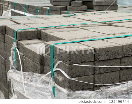 Cobblestones are neatly stacked and secured with straps, ready for a construction project. The site showcases organized materials essential for paving tasks Cobblestones are neatly stacked and secured with straps, ready for a construction project. The site showcases organized materials essential for paving tasks 123496744