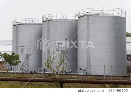 Three large, silo tanks stand side by side at an agricultural facility, capturing the essence of the harvest season as crops are processed and stored 123496805
