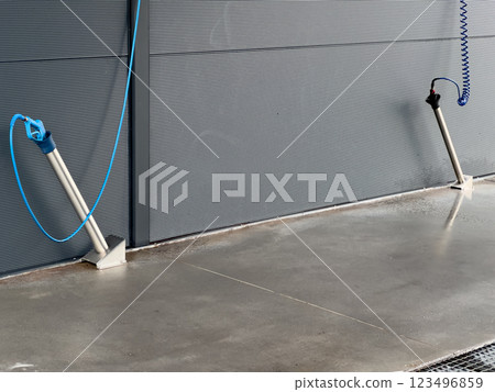 High-pressure washers are positioned for car cleaning, featuring hoses and nozzles, in a well-maintained car wash setting designed for efficient washing 123496859