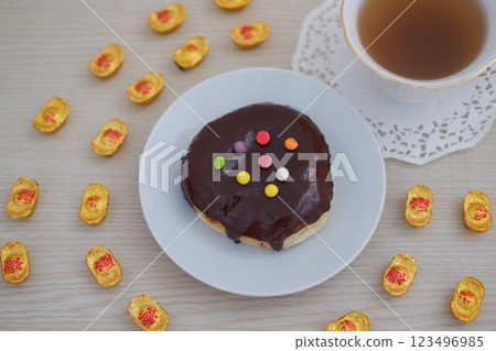 Chocolate Glazed Donut with Colorful Toppings and Tea Chocolate Glazed Donut with Colorful Toppings and Tea 123496985