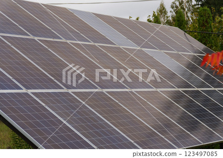 Solar panels glisten under the midday sun in a serene rural setting, showcasing renewable energy's potential while blending harmoniously with nature Solar panels glisten under the midday sun in a serene rural setting, showcasing renewable energy's potential while blending harmoniously with nature 123497085