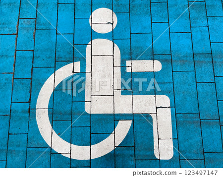 Bright blue pavement displays a clear accessibility symbol, promoting inclusivity in urban environments. This inviting marking encourages awareness and support for individuals with disabilities Bright blue pavement displays a clear accessibility symbol, promoting inclusivity in urban environments. This inviting marking encourages awareness and support for individuals with disabilities 123497147