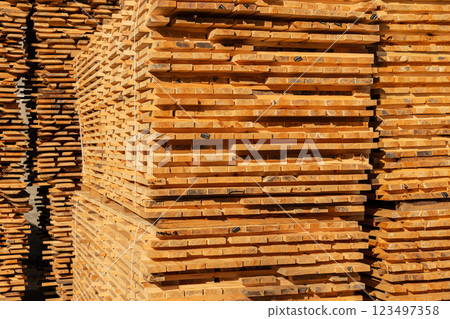 Stacked pine boards on a sawmill. Production of boards. Storage of wooden boards in production 123497358