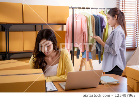 Two young asian businesswoman checking order clothes of customer for laptop computer. 123497962