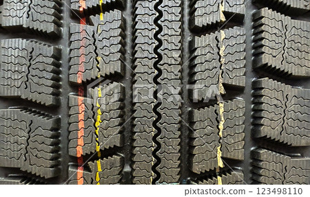 Close-up view of tire tread patterns showcasing varying grooves and wear indicators, essential for traction and performance on different surfaces. 123498110