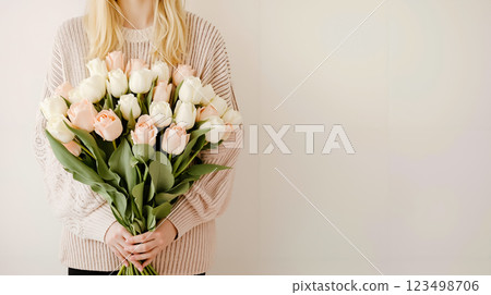A woman holding a bouquet of white and pink roses A woman holding a bouquet of white and pink roses 123498706
