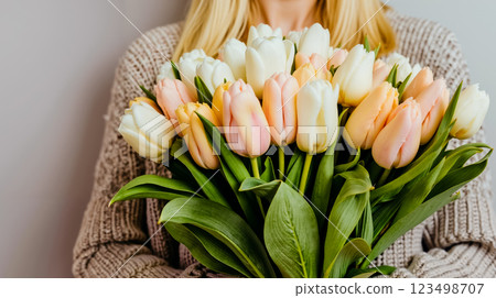 A woman holding a bouquet of white and pink tulips A woman holding a bouquet of white and pink tulips 123498707
