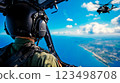 A man in a military uniform is looking out the window of a helicopter 123498708