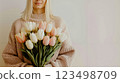 A woman holding a bouquet of white and pink tulips 123498709