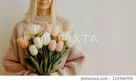 A woman holding a bouquet of white and pink tulips A woman holding a bouquet of white and pink tulips 123498709