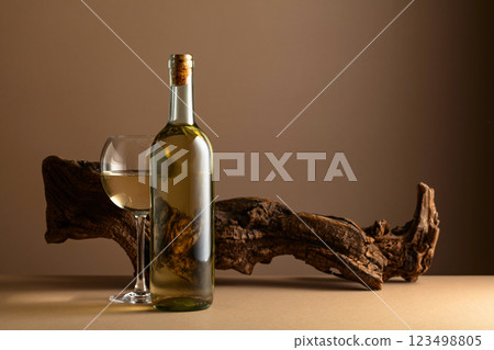 White wine and old snag on a beige background. White wine and old snag on a beige background. 123498805